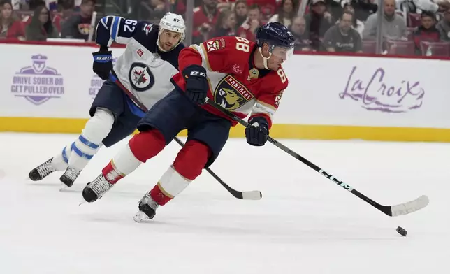 Florida Panthers defenseman Nate Schmidt (88) skates with the puck as Winnipeg Jets right wing Nino Niederreiter (62) pursues during the first period of an NHL hockey game, Saturday, Nov. 16, 2024, in Sunrise, Fla. (AP Photo/Lynne Sladky)