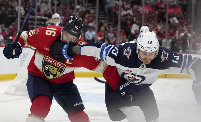 Florida Panthers center Aleksander Barkov (16) and Winnipeg Jets center Gabriel Vilardi (13) go for the puck during the second period of an NHL hockey game, Saturday, Nov. 16, 2024, in Sunrise, Fla. (AP Photo/Lynne Sladky)