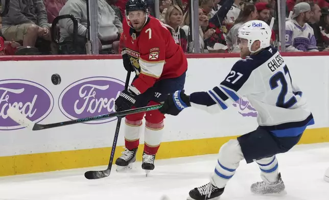 Florida Panthers defenseman Dmitry Kulikov (7) and Winnipeg Jets left wing Nikolaj Ehlers (27) go for the puck during the first period of an NHL hockey game, Saturday, Nov. 16, 2024, in Sunrise, Fla. (AP Photo/Lynne Sladky)