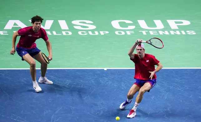 Tommy Paul, right and Ben Shelton of the United States, return the ball to Australia's Matthew Ebden and Jordan Thompson, during their doubles tennis quarterfinal Davis Cup match at the Martin Carpena Sports Hall, in Malaga, southern Spain, on Thursday, Nov. 21, 2024. (AP Photo/Manu Fernandez)