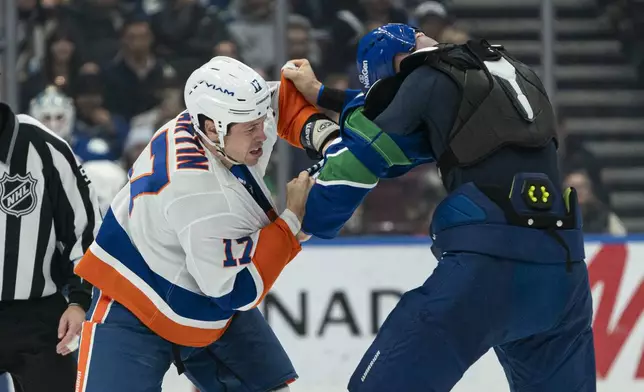 Vancouver Canucks' Vincent Desharnais, right, and New York Islanders' Matt Martin (17) fight during second-period NHL hockey game action in Vancouver, British Columbia, Thursday, Nov. 14, 2024.(Rich Lam/The Canadian Press via AP)