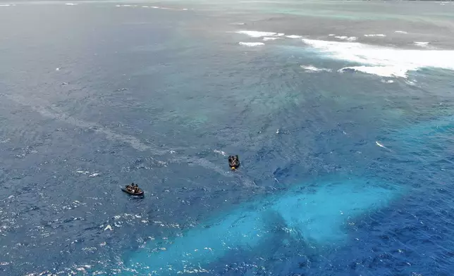 In this photo provided by the New Zealand Defence Force, divers survey the area around HMNZS Manawanui on the southern coast of Upulo, Samoa, after the Manawanui ran aground and sank on Oct. 6. (SGT Vanessa Parker/New Zealand Defence Force via AP)