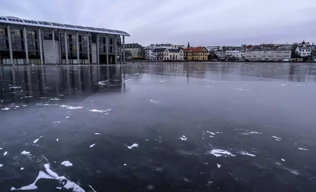 A view of Tjörnin, the city pond completely frozen, with the city hall at left, and downtown Reykjavik in the background, Friday, Nov. 29, 2024. (AP Photo Marco Di Marco)