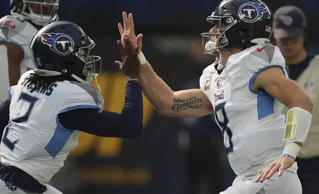 Tennessee Titans running back Tyjae Spears (2) and quarterback Will Levis (8) greets each other before an NFL football game against the Los Angeles Chargers, Sunday, Nov. 10, 2024, in Inglewood, Calif. (AP Photo/Gregory Bull)