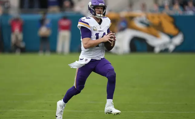 Minnesota Vikings quarterback Sam Darnold (14) runs with the football during the first half of an NFL football game against the Jacksonville Jaguars, Sunday, Nov. 10, 2024, in Jacksonville, Fla. (AP Photo/John Raoux)