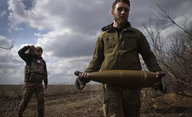 FILE - Ukrainian soldiers carry shells to fire at Russian positions on the front line, near the city of Bakhmut, in Ukraine's Donetsk region, on March 25, 2024. (AP Photo/Efrem Lukatsky, File)