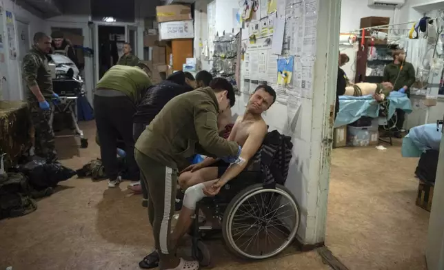 FILE - Military medics give first aid to wounded Ukrainian soldiers near Bakhmut, Ukraine, on Jan. 25, 2024. (AP Photo/Efrem Lukatsky, File)