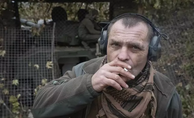 FILE - Volodymyr, a 51 year old soldier of Ukraine's 57th motorised brigade smokes near self-propelled artillery howitzer "Gvozdika" on the front line in the Kharkiv region, Ukraine, on Nov. 7, 2024. (AP Photo/Efrem Lukatsky, File)