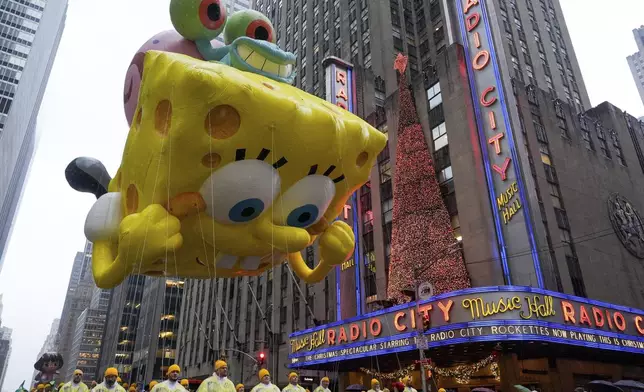 Handlers guide the SpongeBob SquarePants balloon down Sixth Avenue during the Macy's Thanksgiving Day Parade, Thursday, Nov. 28, 2024, in New York. (AP Photo/Julia Demaree Nikhinson)