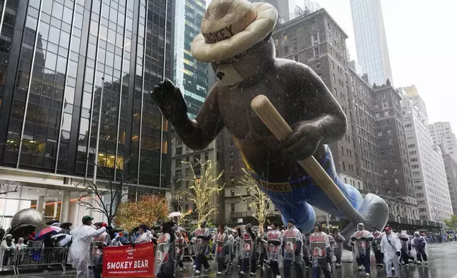 Handlers guide the Smokey Bear balloon down Sixth Avenue during the Macy's Thanksgiving Day Parade, Thursday, Nov. 28, 2024, in New York. (AP Photo/Julia Demaree Nikhinson)