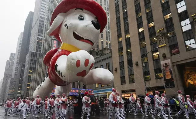 Handlers guide the Marshall from PAW Patrol balloon down Sixth Avenue during the Macy's Thanksgiving Day Parade, Thursday, Nov. 28, 2024, in New York. (AP Photo/Julia Demaree Nikhinson)