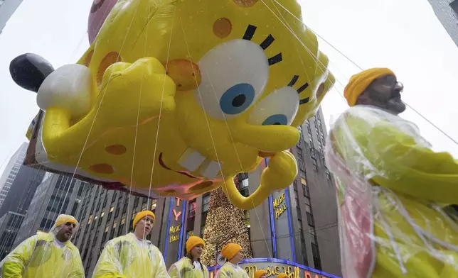 Handlers guide the SpongeBob SquarePants balloon down Sixth Avenue during the Macy's Thanksgiving Day Parade, Thursday, Nov. 28, 2024, in New York. (AP Photo/Julia Demaree Nikhinson)