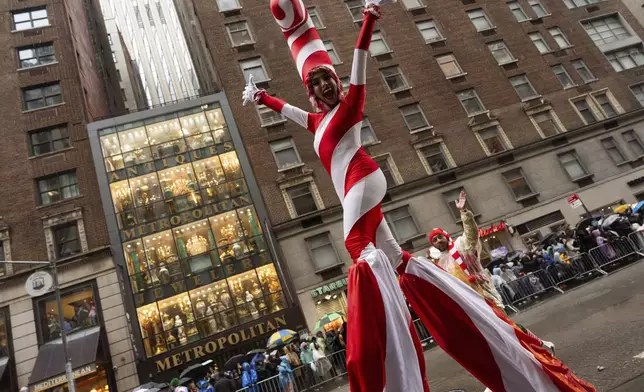 A performer dressed as a candy cane walks down Sixth Avenue during the Macy's Thanksgiving Day Parade, Thursday, Nov. 28, 2024, in New York. (AP Photo/Julia Demaree Nikhinson)