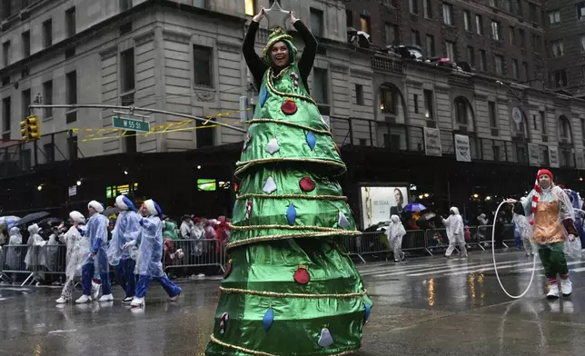 A performer dressed as a Christmas tree walks down Sixth Avenue during the Macy's Thanksgiving Day Parade, Thursday, Nov. 28, 2024, in New York. (AP Photo/Julia Demaree Nikhinson)