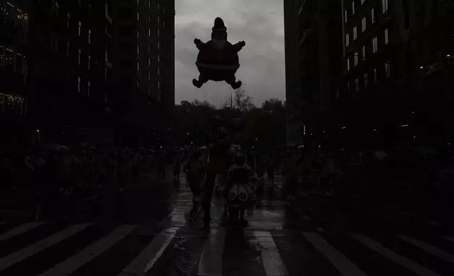 Handlers guide a Santa Claus balloon down Sixth Avenue during the Macy's Thanksgiving Day Parade, Thursday, Nov. 28, 2024, in New York. (AP Photo/Julia Demaree Nikhinson)