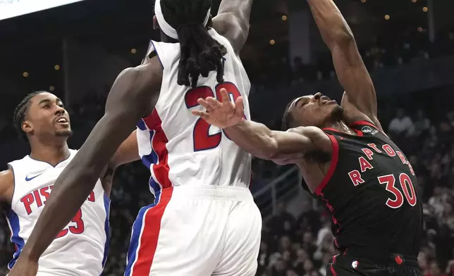 Toronto Raptors' Ochai Agbaji has a shot blocked by Detroit Pistons' Isaiah Stewart during the first half of an Emirates NBA Cup basketball game, Friday, Nov. 15, 2024 in Toronto. (Chris Young/The Canadian Press via AP)