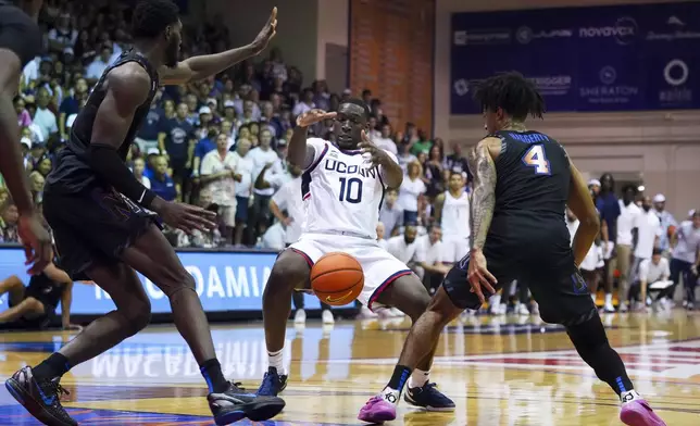 UConn guard Hassan Diarra (10) loses the ball against Memphis center Moussa Cisse, left, and guard PJ Haggerty (4) during the first half of an NCAA college basketball game at the Maui Invitational Monday, Nov. 25, 2024, in Lahaina, Hawaii. (AP Photo/Lindsey Wasson)