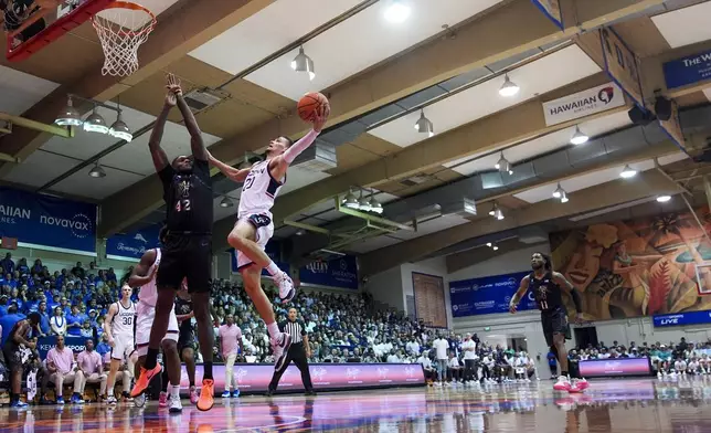 Memphis forward Dain Dainja (42) defends against UConn guard Aidan Mahaney (20) during the first half of an NCAA college basketball game at the Maui Invitational Monday, Nov. 25, 2024, in Lahaina, Hawaii. (AP Photo/Lindsey Wasson)