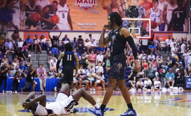 Memphis guard Colby Rogers, right, celebrates a 99-97 win in overtime as UConn guard Hassan Diarra, left, lies on the ground in an NCAA college basketball game at the Maui Invitational Monday, Nov. 25, 2024, in Lahaina, Hawaii. (AP Photo/Lindsey Wasson)