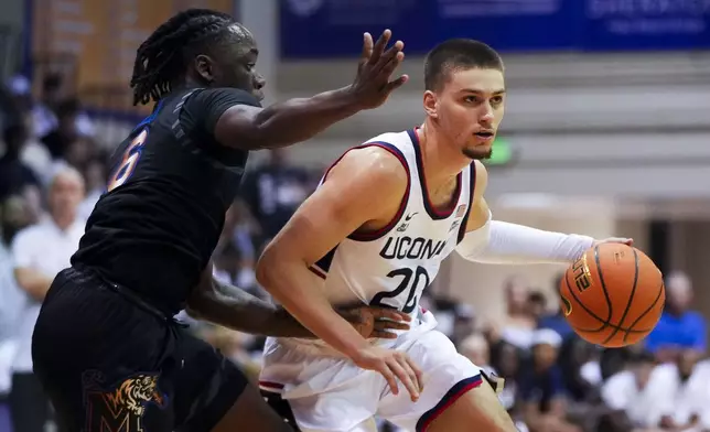 Memphis guard Baraka Okojie (6) guards against UConn guard Aidan Mahaney (20) during the first half of an NCAA college basketball game at the Maui Invitational Monday, Nov. 25, 2024, in Lahaina, Hawaii. (AP Photo/Lindsey Wasson)