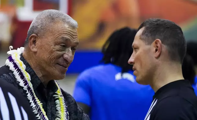 Maui County mayor Richard Bissen, left, talks with an official before an NCAA college basketball game between UConn and Memphis at the Maui Invitational Monday, Nov. 25, 2024, in Lahaina, Hawaii. (AP Photo/Lindsey Wasson)