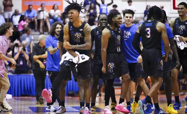 Memphis guard PJ Haggerty, left, reacts to beating UConn 99-97 in overtime in an NCAA college basketball game at the Maui Invitational Monday, Nov. 25, 2024, in Lahaina, Hawaii. (AP Photo/Lindsey Wasson)