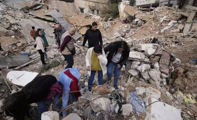 Displaced residents react as they stand in front of the rubble of their destroyed house in Baalbek, eastern Lebanon, Thursday, Nov. 28, 2024. (AP Photo/Hassan Ammar)