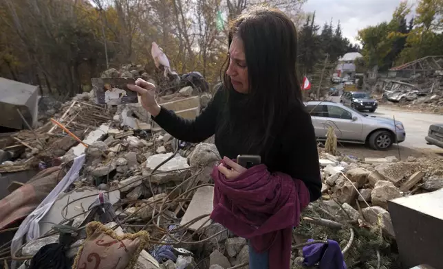 Zeina Rida Jawhari, reacts after recovering a photo of her father from the rubble of her destroyed house in Baalbek, eastern Lebanon, Thursday, Nov. 28, 2024. (AP Photo/Hassan Ammar)