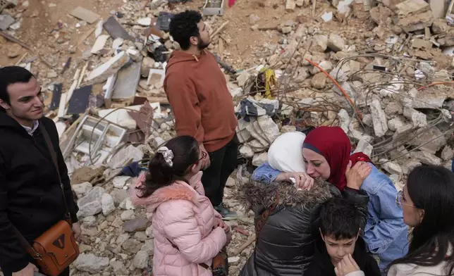 Displaced residents pause and hug as they stand in front of the rubble of their destroyed house in Baalbek, eastern Lebanon, Thursday, Nov. 28, 2024. (AP Photo/Hassan Ammar)