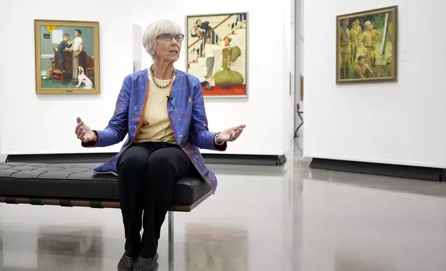 Judge Barbara Houser responds to a question during an interview at Heritage Auctions in Dallas, Thursday, Oct. 17, 2024, as she sits by a collection of paintings from the Boy Scouts of America's storied collection that will be going up for auction. (AP Photo/Tony Gutierrez)