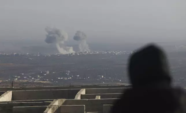 CORRECTS CITY Smoke rises amid fighting between opposition factions and Syrian government troops in Majdaliya, Idlib countryside, Syria, Thursday, Nov. 28, 2024. (AP Photo/Ghaith Alsayed)