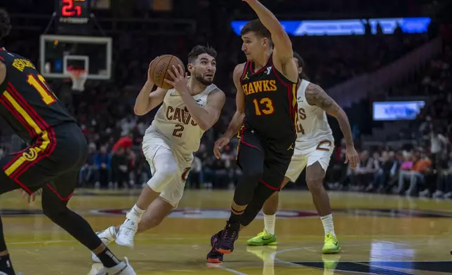 Cleveland Cavaliers guard Ty Jerome (2) attempts to pass the ball against Atlanta Hawks guard Bogdan Bogdanovic (13) during the first half of an Emirates NBA Cup basketball game Friday, Nov. 29, 2024, in Atlanta. (AP Photo/Erik Rank)