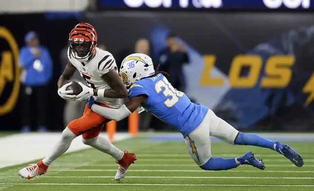 Cincinnati Bengals wide receiver Tee Higgins (5) is tackled by Los Angeles Chargers cornerback Ja'Sir Taylor (36) after a catch during the second half of an NFL football game Sunday, Nov. 17, 2024, in Inglewood, Calif. (AP Photo/Eric Thayer)