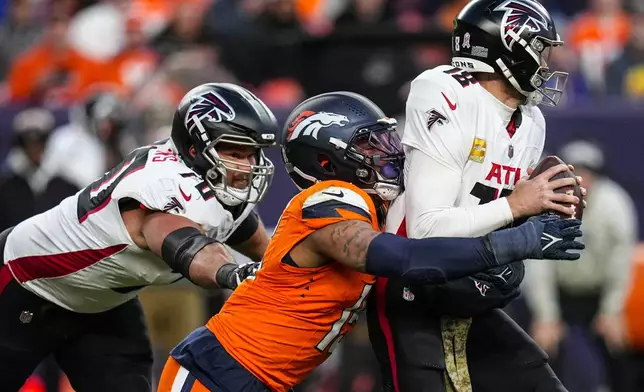 Denver Broncos linebacker Nik Bonitto (15) sacks Atlanta Falcons quarterback Kirk Cousins (18) during the second half of an NFL football game, Sunday, Nov. 17, 2024, in Denver. (AP Photo/Jack Dempsey)