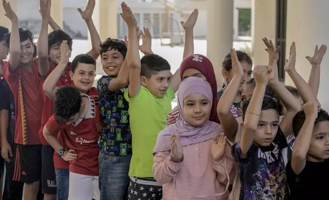 Volunteers of the Russian Cultural Center entertain displaced children at a school in Beirut, Lebanon, Thursday, Oct. 3, 2024, after fleeing the Israeli airstrikes in the south. (AP Photo/Bilal Hussein)