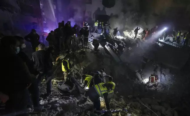 Rescue workers and people search for victims at the site of an Israeli airstrike in Beirut, Lebanon, early Saturday, Nov. 23, 2024. (AP Photo/Bilal Hussein)