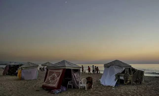 Tents set up as temporary shelters by displaced families fleeing the Israeli airstrikes in the south and Dahiyeh, are seen along the Ramlet al-Baida public beach in Beirut, Lebanon, Tuesday Oct. 8, 2024. (AP Photo/Bilal Hussein)