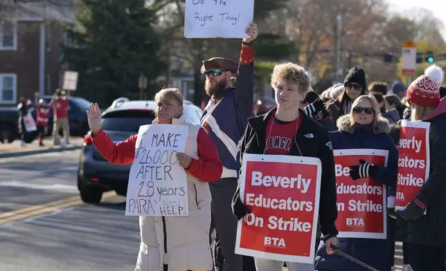 Striking teachers and supporters stand on the picket line, Friday, Nov. 22, 2024, in Beverly, Mass., to call attention to pay, paid parental leave, and other contract issues. (AP Photo/Charles Krupa)