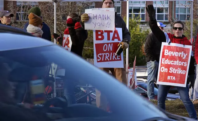 Striking teachers and supporters stand on the picket line, Friday, Nov. 22, 2024, in Beverly, Mass., to call attention to pay, paid parental leave, and other contract issues. (AP Photo/Charles Krupa)