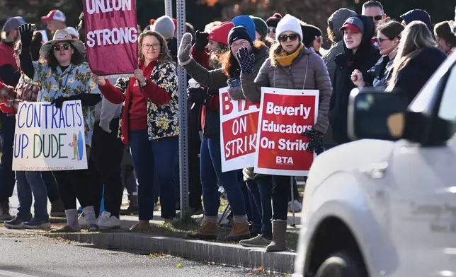 Striking teachers and supporters stand on the picket line, Friday, Nov. 22, 2024, in Beverly, Mass., to call attention to pay, paid parental leave, and other contract issues. (AP Photo/Charles Krupa)