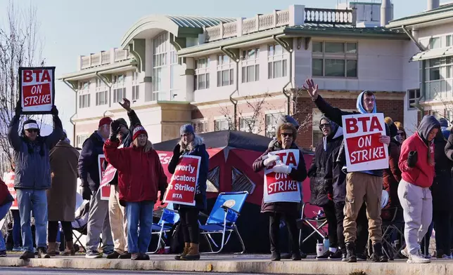 Striking teachers and supporters stand on the picket line, Friday, Nov. 22, 2024, in Beverly, Mass., to call attention to pay, paid parental leave, and other contract issues. (AP Photo/Charles Krupa)