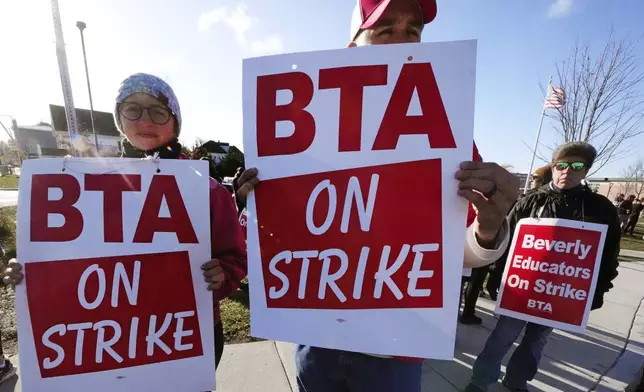 Striking teachers and supporters stand on the picket line, Friday, Nov. 22, 2024, in Beverly, Mass., to call attention to pay, paid parental leave, and other contract issues. (AP Photo/Charles Krupa)