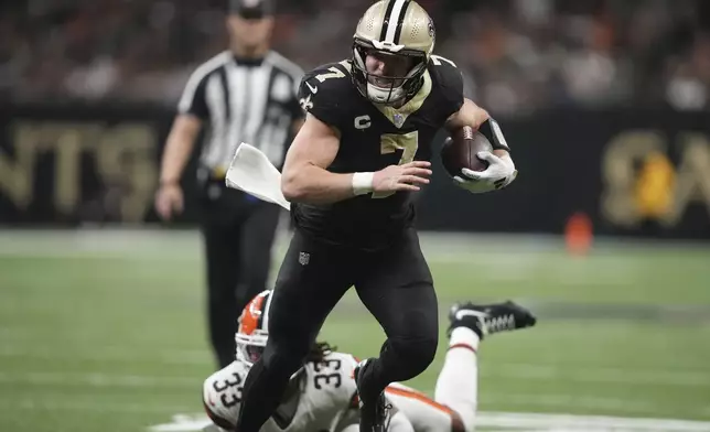 New Orleans Saints tight end Taysom Hill (7) carries in for a touchdown pst Cleveland Browns safety Ronnie Hickman (33) in the second half of an NFL football game in New Orleans, Sunday, Nov. 17, 2024. (AP Photo/Gerald Herbert)