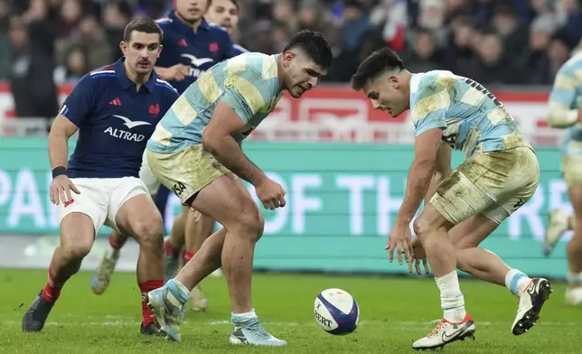 Argentina's Tomas Albornoz, right, and teammate Joaquin Oviedo reach for the ball as France's Thomas Ramos, left, watchescduring the Autumn Nations Series rugby international between France and Argentina at the Stade de France stadium at Saint-Denis on the outskirts of Paris, Friday, Nov. 22, 2024. (AP Photo/Thibault Camus)