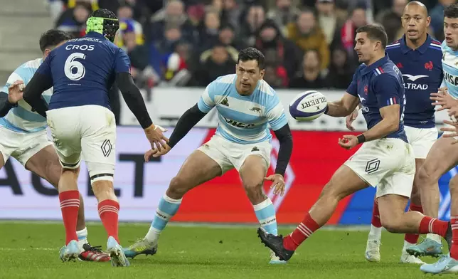 France's Thomas Ramos passes the ball to teammate Francois Cros, left, during the Autumn Nations Series rugby international between France and Argentina at the Stade de France stadium at Saint-Denis on the outskirts of Paris, Friday, Nov. 22, 2024. (AP Photo/Thibault Camus)