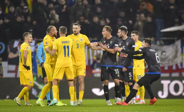 Romania's Radu Dragusin, center, breaks up a scuffle between Romania's Denis Alibec, left, and Kosovo's Mergim Vojvoda during the UEFA Nations League soccer match between Romania and Kosovo was suspended at the National Arena stadium in Bucharest, Romania, Saturday, Nov. 16, 2024. (AP Photo/Alexandru Dobre)