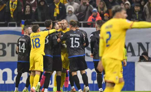Kosovo's Amir Rrahmani, left, argues with Romania's Denis Alibec during the UEFA Nations League soccer match between Romania and Kosovo was suspended at the National Arena stadium in Bucharest, Romania, Saturday, Nov. 16, 2024. (AP Photo/Alexandru Dobre)
