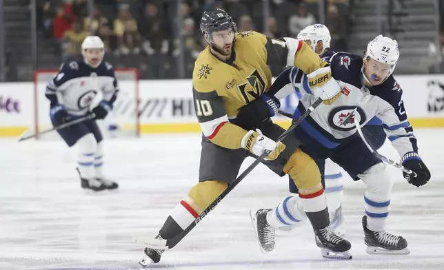 Vegas Golden Knights center Nicolas Roy (10) and Winnipeg Jets center Mason Appleton (22) collide during the first period of an NHL hockey game Friday, Nov. 29, 2024, in Las Vegas. (AP Photo/Ian Maule)