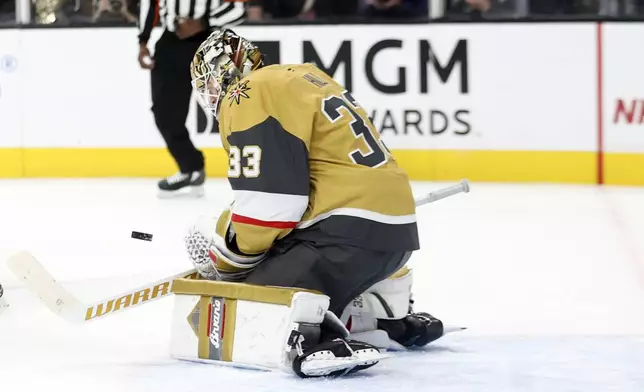 Vegas Golden Knights goaltender Adin Hill (33) makes a save during the first period of an NHL hockey game against the Winnipeg Jets, Friday, Nov. 29, 2024, in Las Vegas. (AP Photo/Ian Maule)