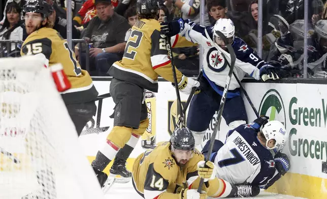 Vegas Golden Knights right wing Cole Schwindt (22) and defenseman Nicolas Hague (14) collide with Winnipeg Jets left wing Alex Iafallo (9) and center Vladislav Namestnikov (7) during the first period of an NHL hockey game Friday, Nov. 29, 2024, in Las Vegas. (AP Photo/Ian Maule)